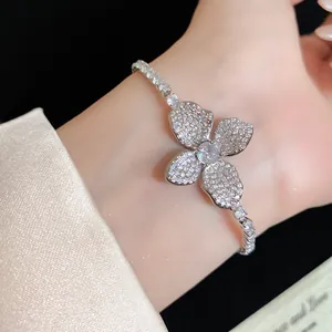 Dettaglio dell'elegante bracciale con fiori di zircone sul polso femminile