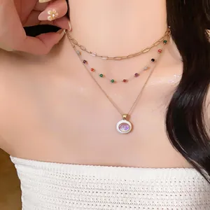 Detailed view of a multi-layered gold necklace with colorful beads and circular pendant.