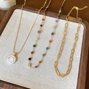 Collection of gold-colored necklaces featuring colorful beads and chunky link chains