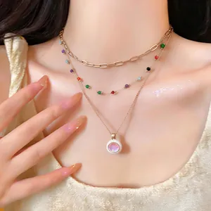 Close-up of multi-layer necklace with colorful beads and iridescent opal-like pendant