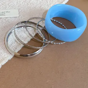 Close-up of stylish mixed resin and silver-tone metal bangle bracelet set for women