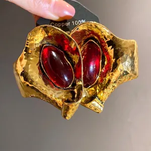Orecchini vintage in oro martellato con pietre in resina rossa per un look sofisticato.