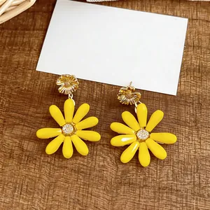 Close-up detail of vibrant yellow daisy earrings with a sparkling central zircon stone