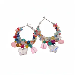 Handmade colorful crystal beaded hoop earrings with butterfly and flower charms on white background