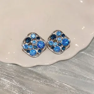 Elegant hollow square stud earrings featuring sparkling blue rhinestones in a silver frame