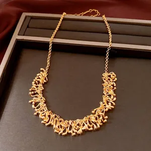 Élégant collier doré avec pampilles géométriques irrégulières sur un plateau à bijoux sombre