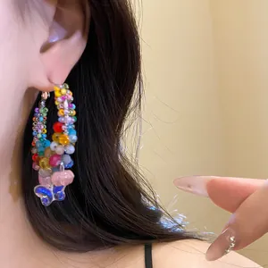 Close-up view of colorful handcrafted beaded hoop earrings with blue butterfly charm