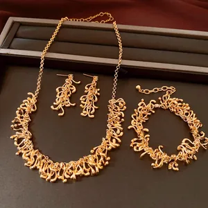 Vue détaillée de l'ensemble de bijoux à pompons géométriques irréguliers dorés