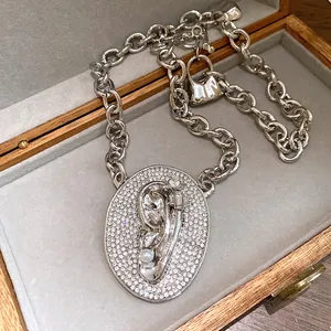 Detailed close-up of a surrealist silver-colored ear pendant necklace with pearls.