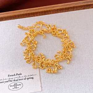 Gros plan détaillé d'un bracelet doré géométrique irrégulier avec un design de gland unique