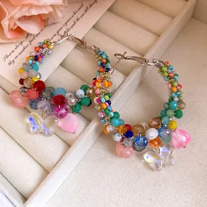Detailed macro view of colorful beaded hoop earrings with butterfly and heart charms