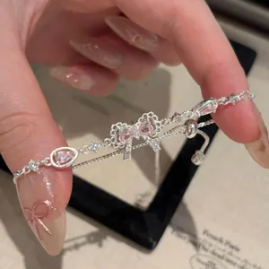 Detailed macro shot of an elegant silver bow bracelet with pink zircon stones for women