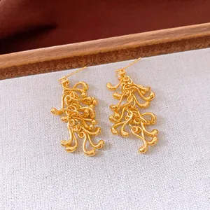 Vue détaillée des boucles d'oreilles pampilles géométriques irrégulières dorées et zircons