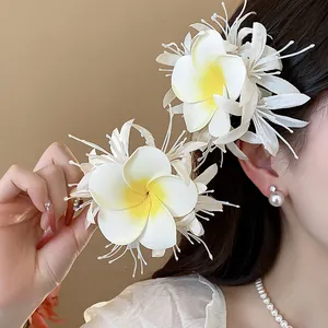 Detailaufnahme von weißen Plumeria-Stoff-Haarspangen an einem Modell für einen süßen Look