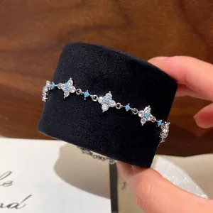 Elegant silver-toned flower bracelet with zircons and turquoise beads on black display roll