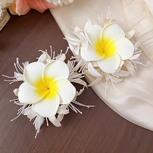 Nahaufnahme weiß-gelber Stoff-Plumeria-Haarspangen mit feinen Blütendetails.