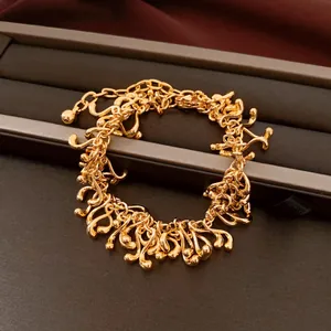 Vue rapprochée d'un bracelet doré avec des glands géométriques irréguliers chic.