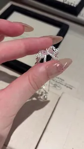 Close-up detail of an exquisite silver bracelet featuring a pink zircon bow pendant design