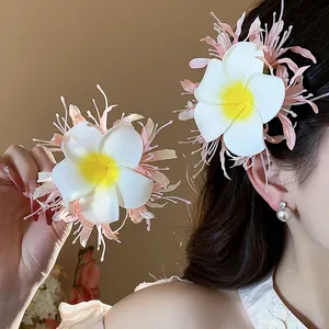 Zierliche Plumeria-Haarklammer aus Stoff mit rosa Fransen für süße Urlaubsfrisuren.