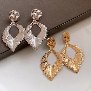Textured gold and silver leaf-shaped drop earrings with a vintage metallic finish