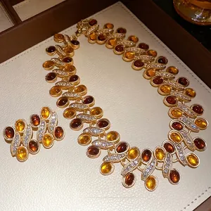 Vintage gold-toned jewelry set featuring amber resin cabochons and sparkling rhinestones