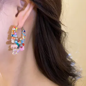 Detailed close-up view of colorful crystal beaded hoop earrings with a butterfly charm
