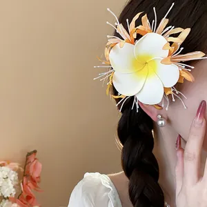 Detailansicht einer lebendigen Stoffblumen-Haarklammer an einem geflochtenen Zopf.
