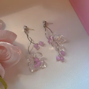 Detail view of purple flower tassel earrings with clear petals and lavender beads.