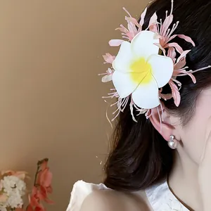 Nahaufnahme einer eleganten weißen Plumeria-Stoffblumen-Haarspange mit rosa Akzenten