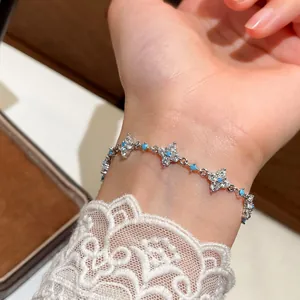 Detailed view of an elegant silver bracelet with zircon flowers and turquoise beads on wrist