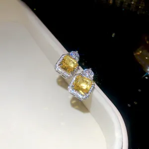 Macro view of exquisite square yellow zircon stud earrings with sparkling halo detail
