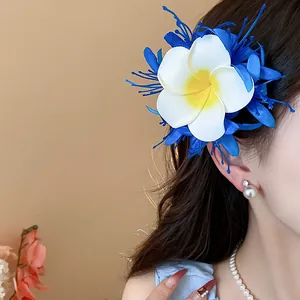 Detailaufnahme einer blau-weißen tropischen Stoffblumen-Haarspange an einem weiblichen Modell