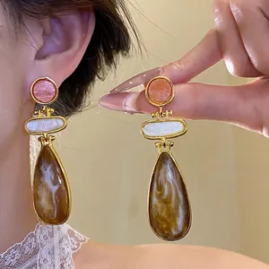 Vintage-style tiered resin drop earrings featuring pink, white, and marbled brown elements.