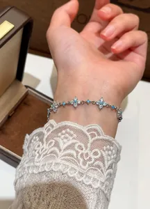 Close-up detail of silver flower bracelet with zircon and turquoise beads on wrist