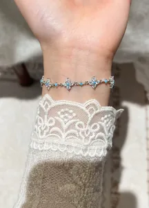 Detailed view of an elegant zircon flower bracelet with blue turquoise beads on a wrist