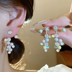 Nahaufnahme bunter Ohrringe im Dopamin-Stil mit Emaille-Perlen und funkelnden Zirkonia.