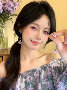 Beautiful model wearing elegant zircon flower tassel earrings in a sweet vacation style