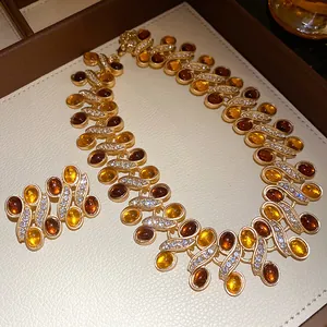 Detailed view of vintage amber resin and rhinestone jewelry set with necklace and earrings