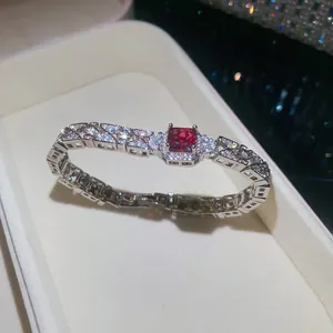 Detailed close-up of a luxury bracelet featuring a red square gemstone and clear zirconia