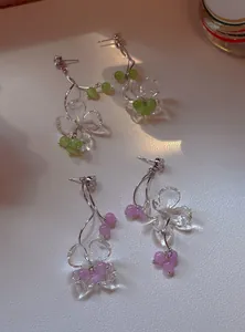 Detailed shot of zircon flower tassel earrings with transparent petals and colored beads