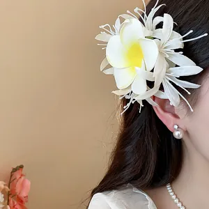 Detailansicht einer großen Stoff-Frangipani-Haarklammer im langen Haar eines Models