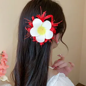 Detailansicht einer eleganten weißen und roten Plumeria-Stoffhaarspange für langes Haar