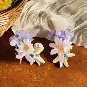 Macro view of handmade seashell and starfish hair clips with delicate fabric flowers