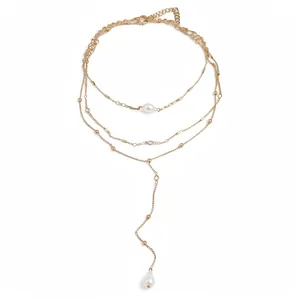 Elegant gold-tone multi-layer necklace featuring chic white pearl pendants on a Y-drop chain