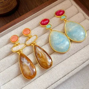 Close-up of vintage resin teardrop earrings with marble texture in a jewelry box