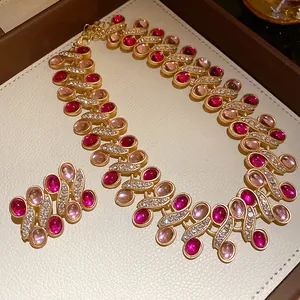 Close-up of vintage gold necklace and earring set with pink resin stones and rhinestones