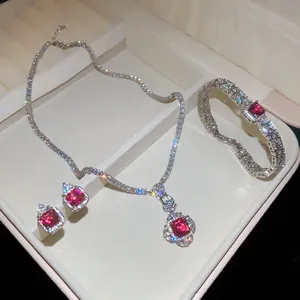 Close-up of a sparkling zircon jewelry set with square red stones and silver plating.