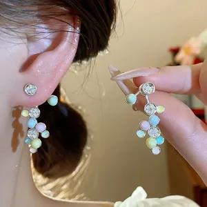 Detailansicht bunter Dopamin-Zirkon-Ohrstecker mit pastellfarbenen Perlen und Silbernadeln.