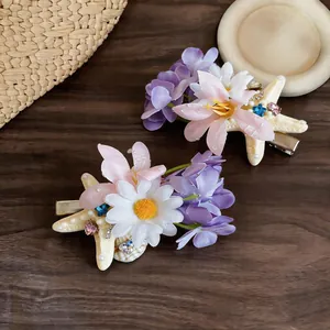 Detailed view of handmade fabric flower and starfish hair clips with pearl accents