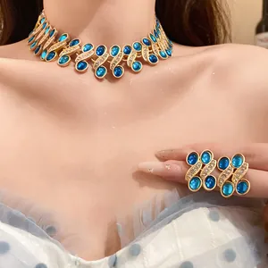 Close-up of vintage gold necklace and earrings set with blue stones and rhinestones